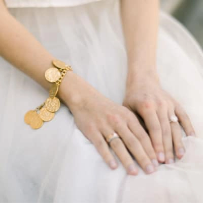 This is an image of a woman in a wedding dress showing offer he hand jewelry.